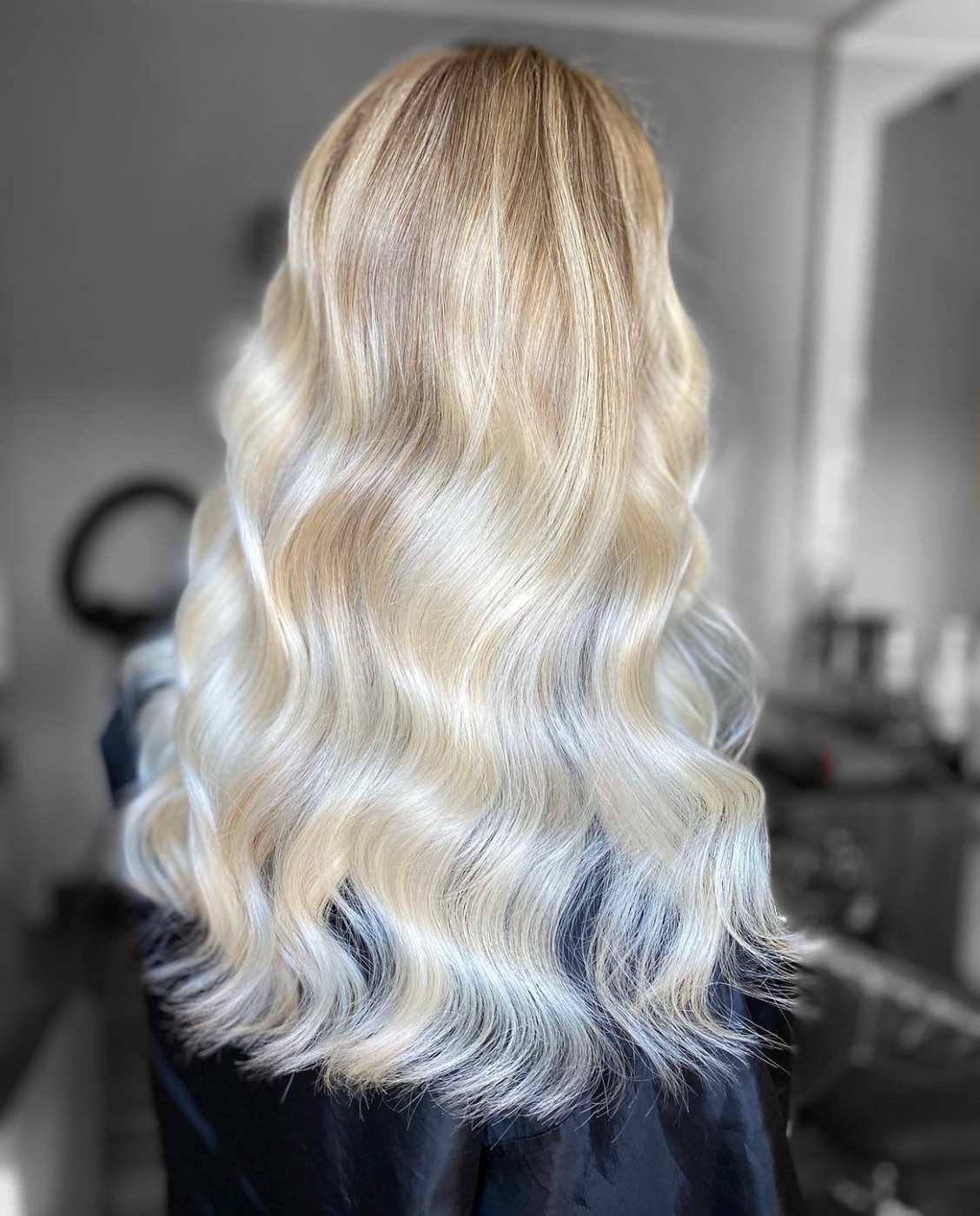 Degradè platino su capelli lunghi con radice naturale sfumata